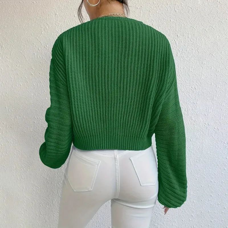 A woman wearing a solid colour long sleeve loose pullover top in a casual setting.