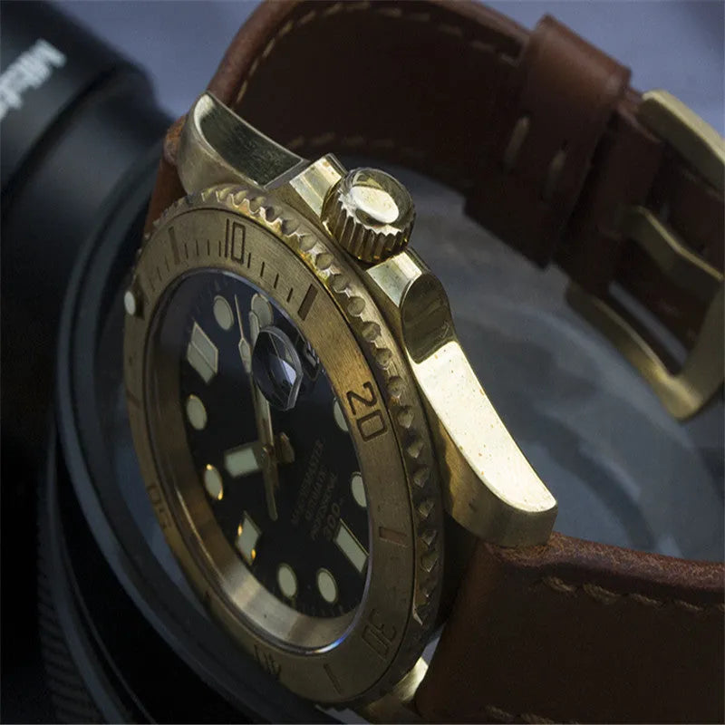 Men's vintage bronze automatic diving watch with gold dial and genuine leather strap on a wooden surface