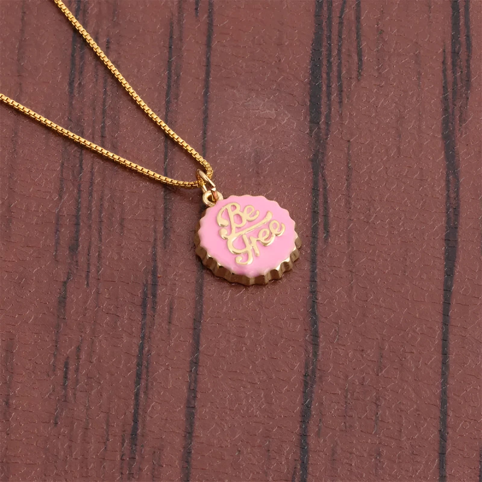 Copper Be Free bottle cap pendant necklace on a 40cm box chain with gold electroplating.