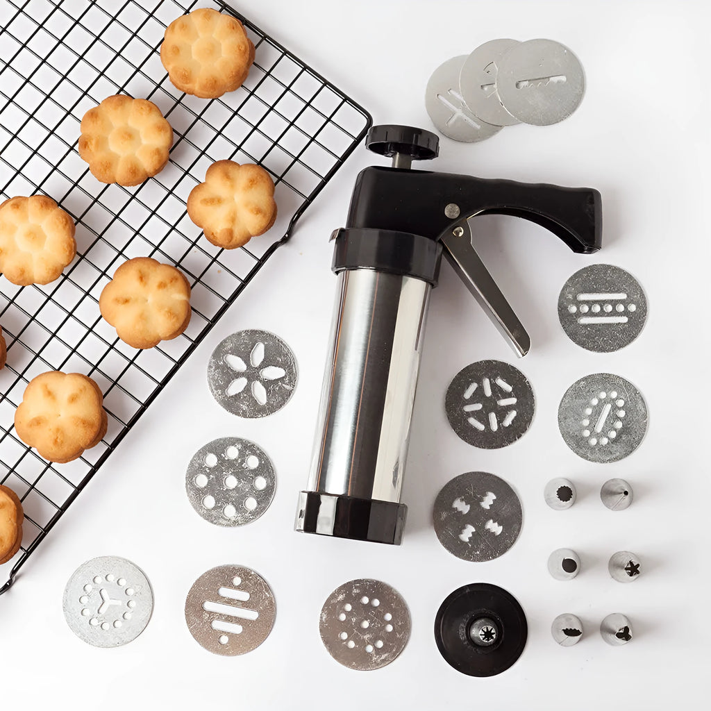 Stainless steel biscuit press gun with assorted cookie moulds and piping nozzles for baking.