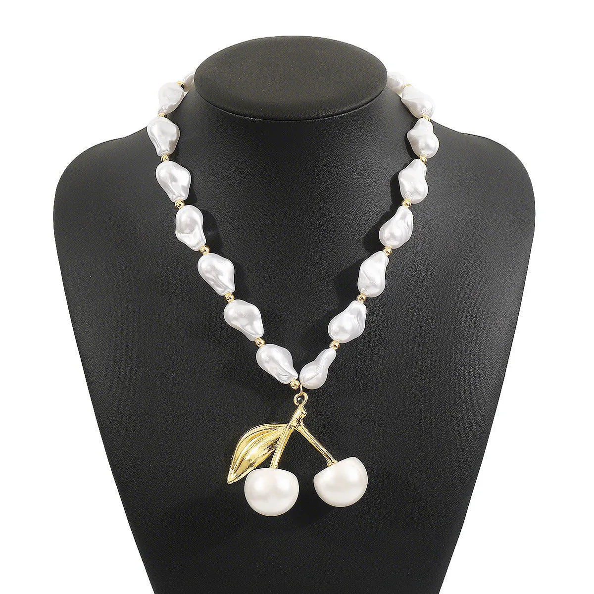 Gold-coloured women's necklace with a cherry fruit pendant on a pearl-style chain.