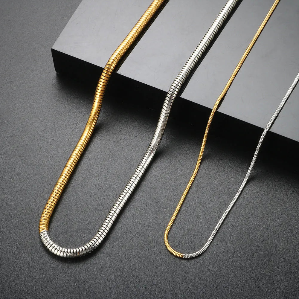 Close-up of a women's golden snake bones chain necklace with geometric lines, 3mm wide.