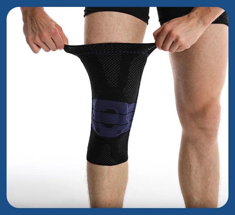 A pair of adult sports knee pads in a black and blue colourway, shown on a knee for scale.