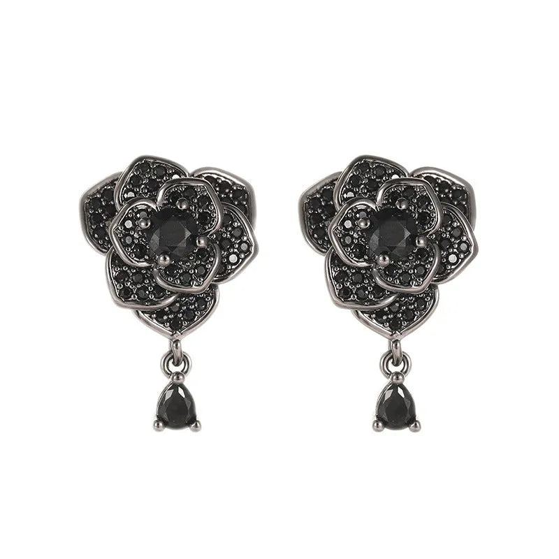Close-up of women's black rose zircon flower stud earrings with 18K gold plating.