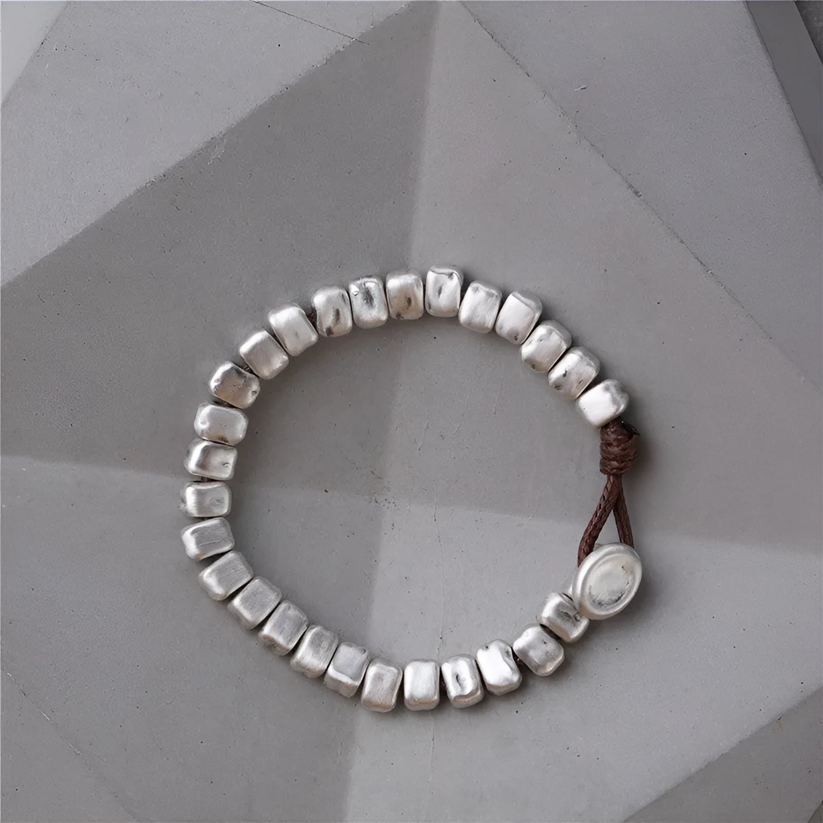 Women's handmade bracelet with irregular silver squares and wooden accents on elastic band