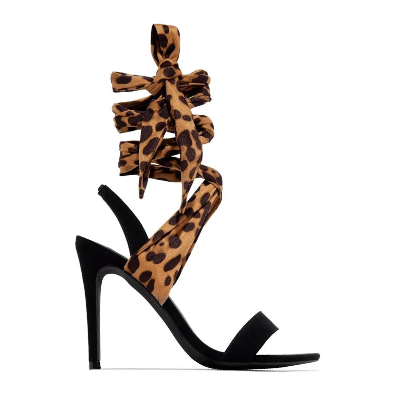 Light brown leopard print women's high-heeled sandals with cross straps and a stiletto heel.