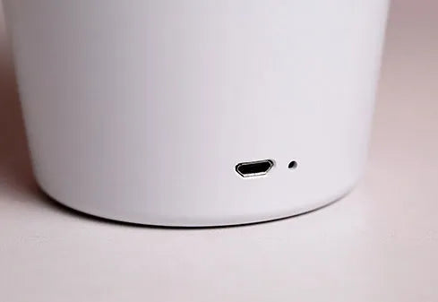 Modern rechargeable LED table lamp in pink with touch control and plant-shaped design on a wooden desk