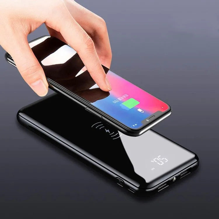 Multifunctional mirror wireless charger with silver mirror finish and built-in lithium battery on a wooden desk.