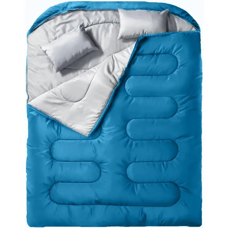Seven-in-one pillow size sleeping bag in black double, folded to compact cushion shape on outdoor ground