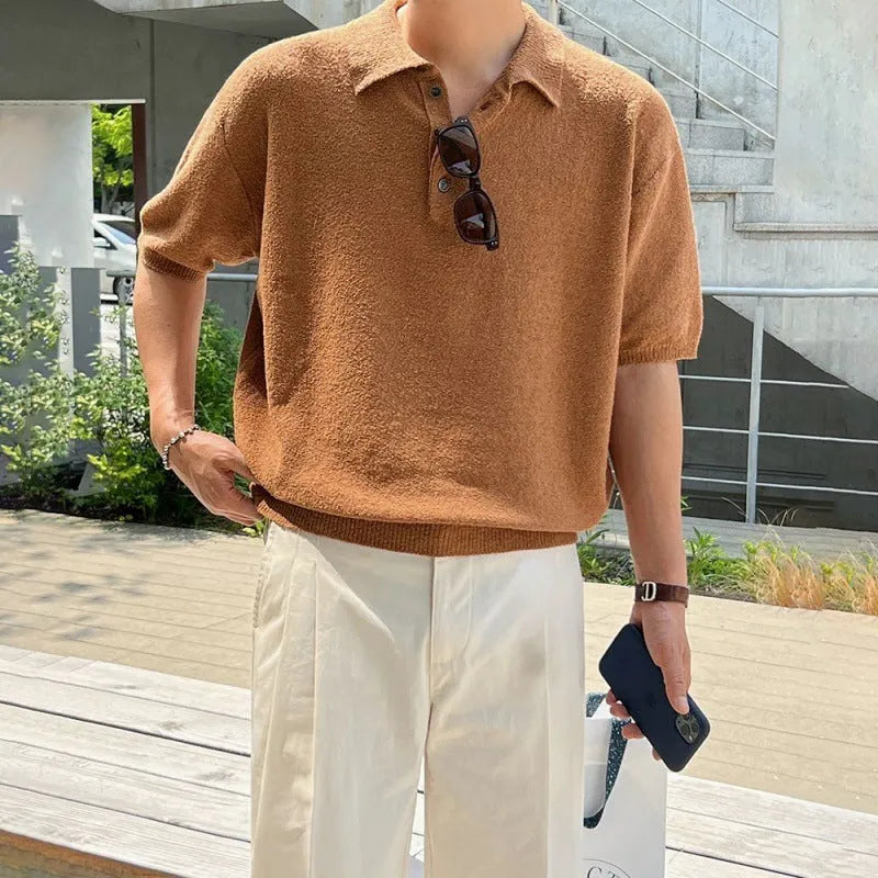 Man modelling a caramel coloured loose-fit knitted short sleeve polo shirt with an asymmetric design.