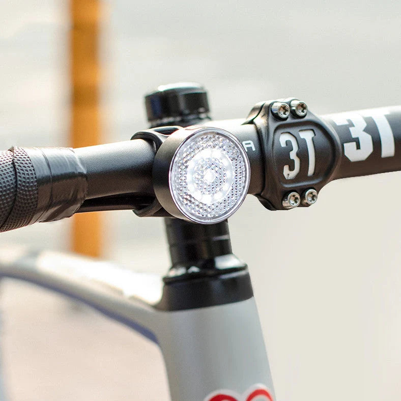 Bicycle LED headlight with clip attachment showing lens reflectors and USB port for charging