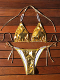 Gold women's bikini swimsuit with halter neck, lace-up back, and pearl chain decoration