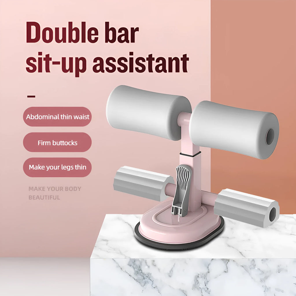 Pink adjustable sit-up bar with foam handles and suction base on a smooth floor for home fitness