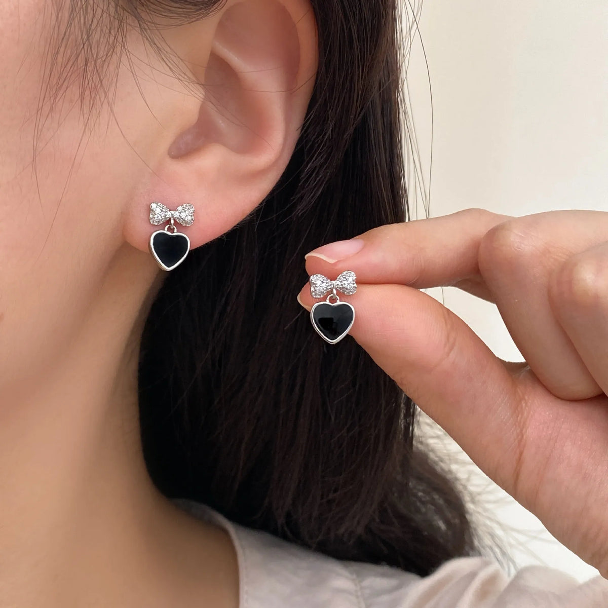 Copper earrings with inlaid zircon heart and bow shapes as a pair of ear clips or ear studs