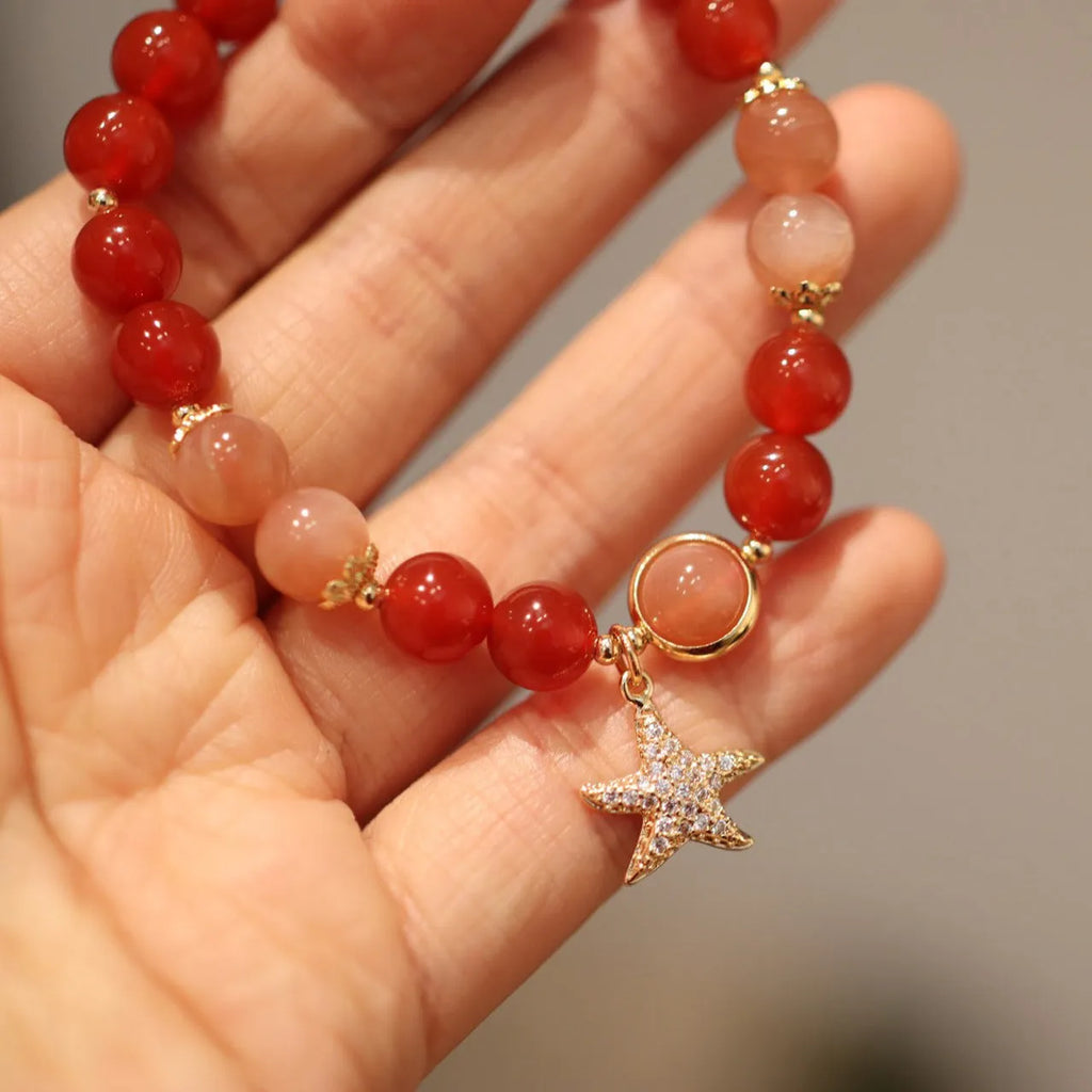 Handmade women's bracelet with 8mm red agate and sunstone beads in ethnic XINGX design featuring star and xiangyun elements