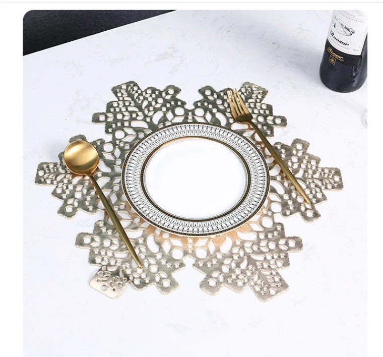 Stylish snowflake-patterned placemats in gold and silver, designed for heat resistance and spill protection on dining tables