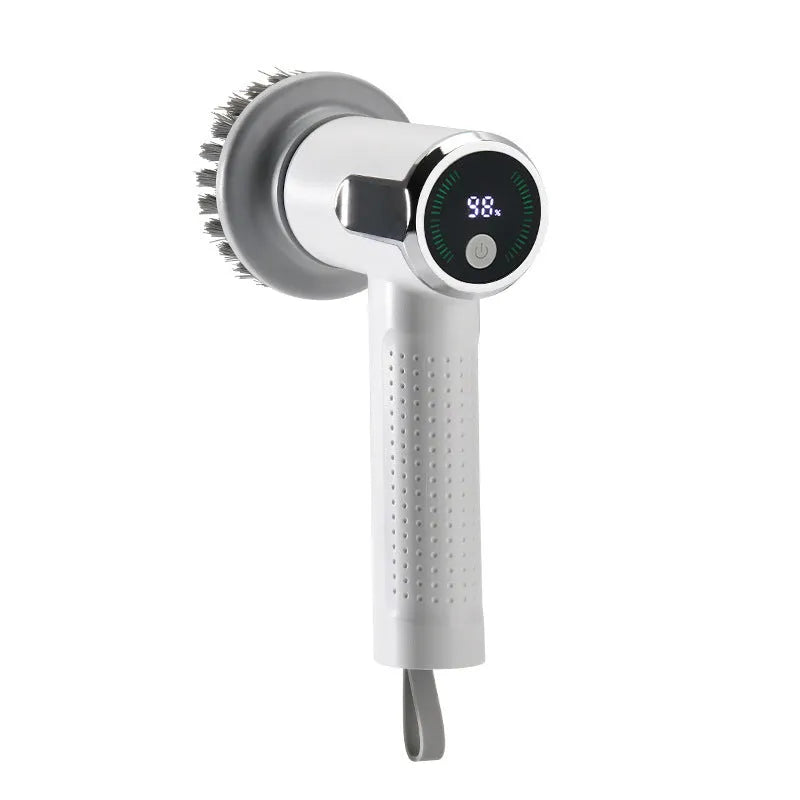 White cordless electric cleaning brush with interchangeable brush heads on a kitchen counter.