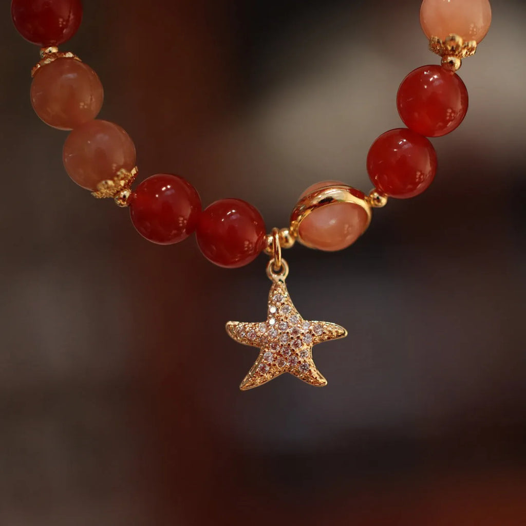 Handmade women's bracelet with 8mm red agate and sunstone beads in ethnic XINGX design featuring star and xiangyun elements