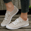 Women's creamy white low-top fabric sneakers with a casual rubber sole on a neutral background