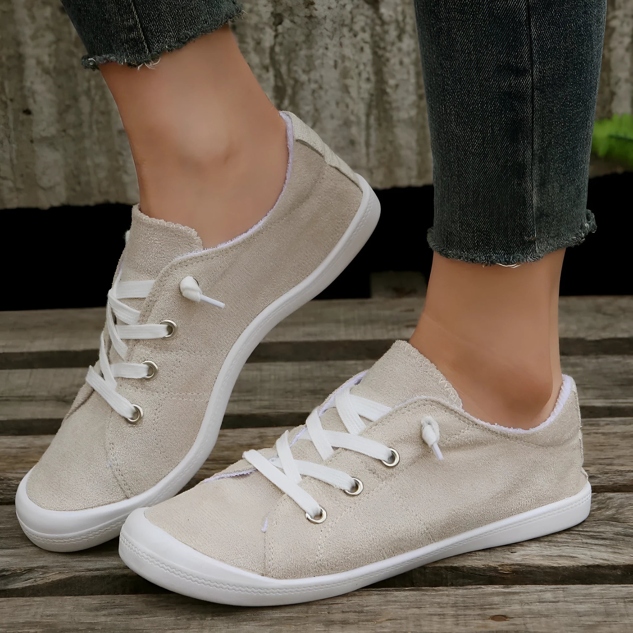 Women's creamy white low-top fabric sneakers with a casual rubber sole on a neutral background