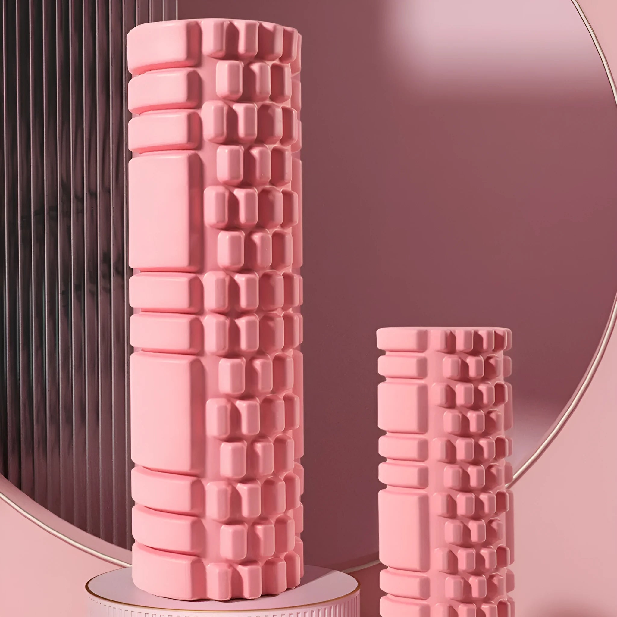 EVA foam roller in black, shown next to smaller pink and sky blue rollers of different sizes.