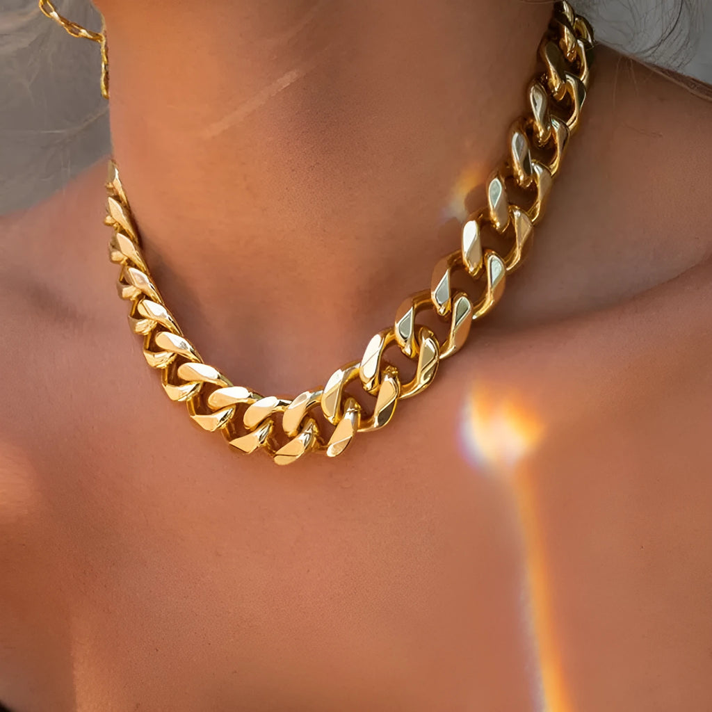 Gold coloured women's thick chain necklace on a white background.