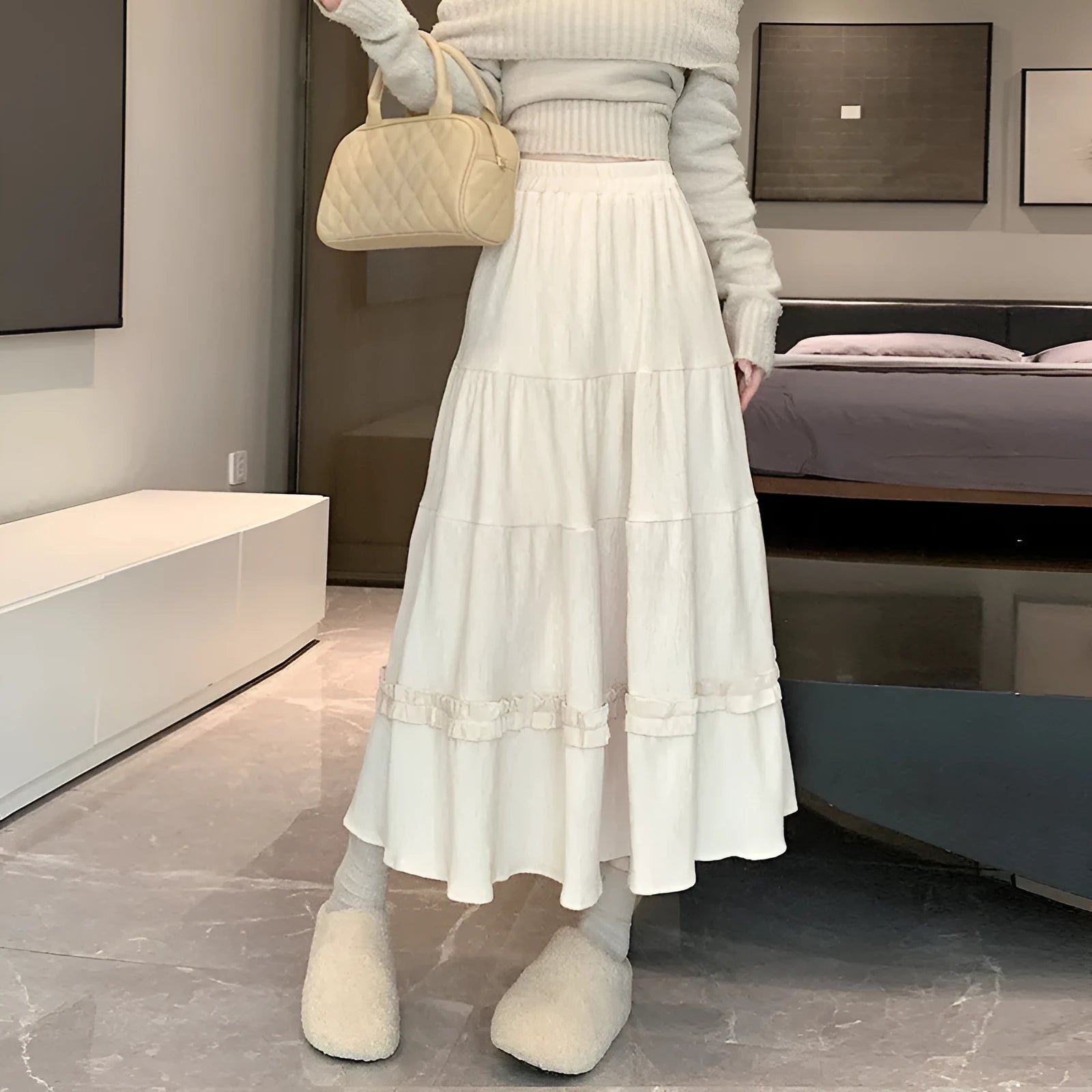 Women's milky white corduroy A-line midi skirt with an elastic waistband, laid flat.