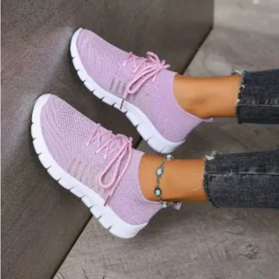 Breathable women's flying knit flat shoes in beige with mesh upper, round toe, low heel, and front tie closure.