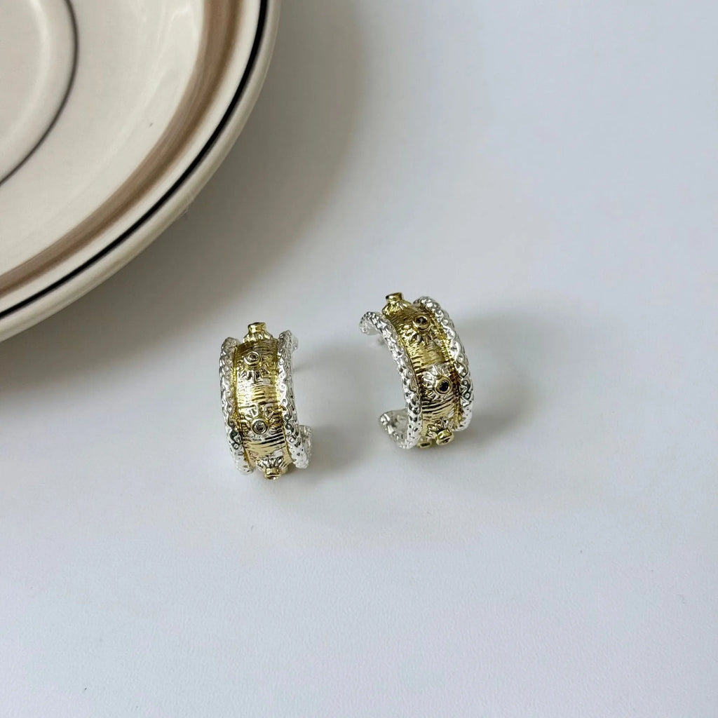 Gold and silver colour matching C-shaped brushed ring earrings with 925 silver needle on display