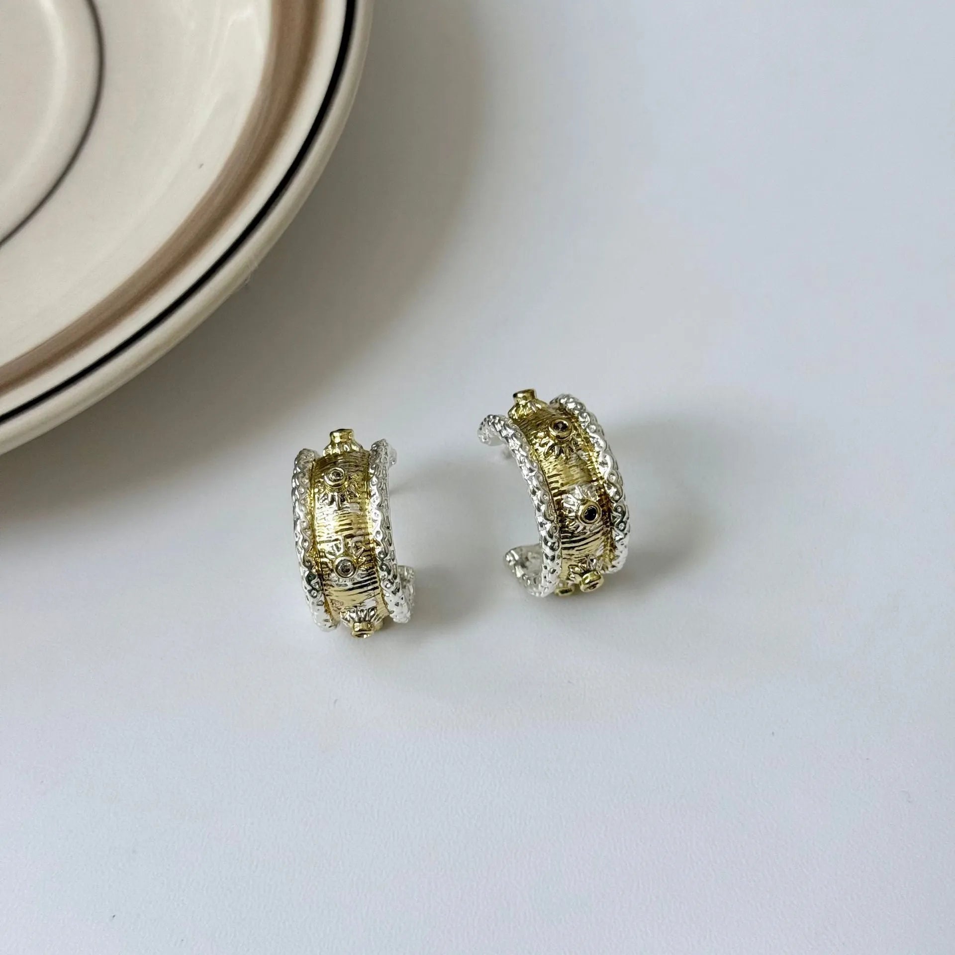 Gold and silver colour matching C-shaped brushed ring earrings with 925 silver needle on display