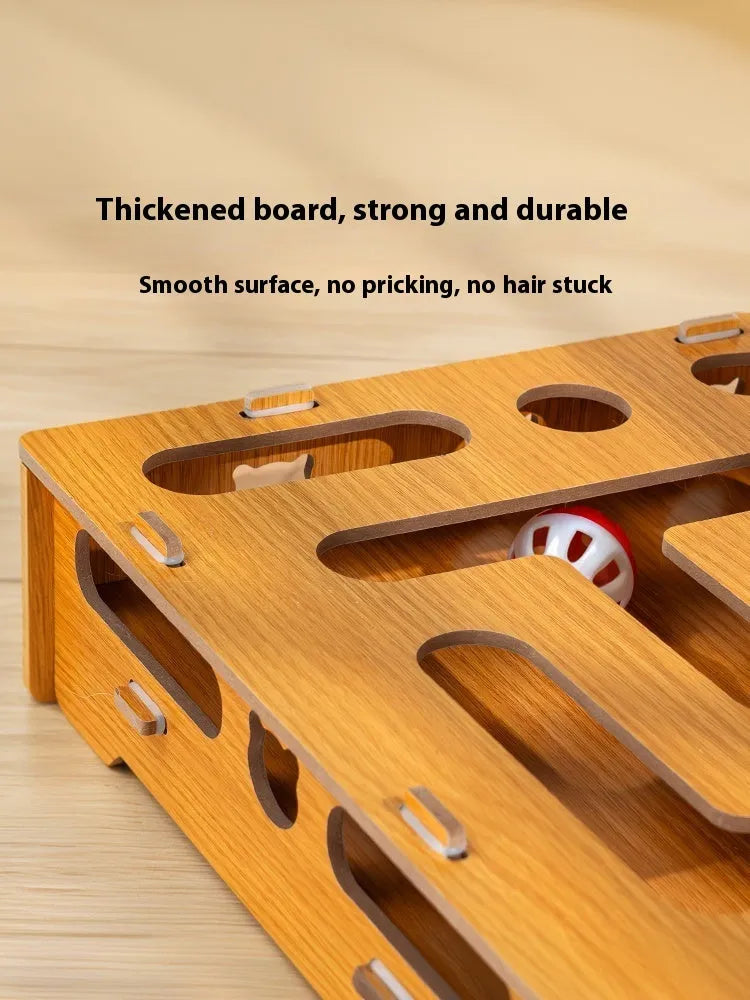 Wooden cat maze box with teasing stick and two bell balls on a floor