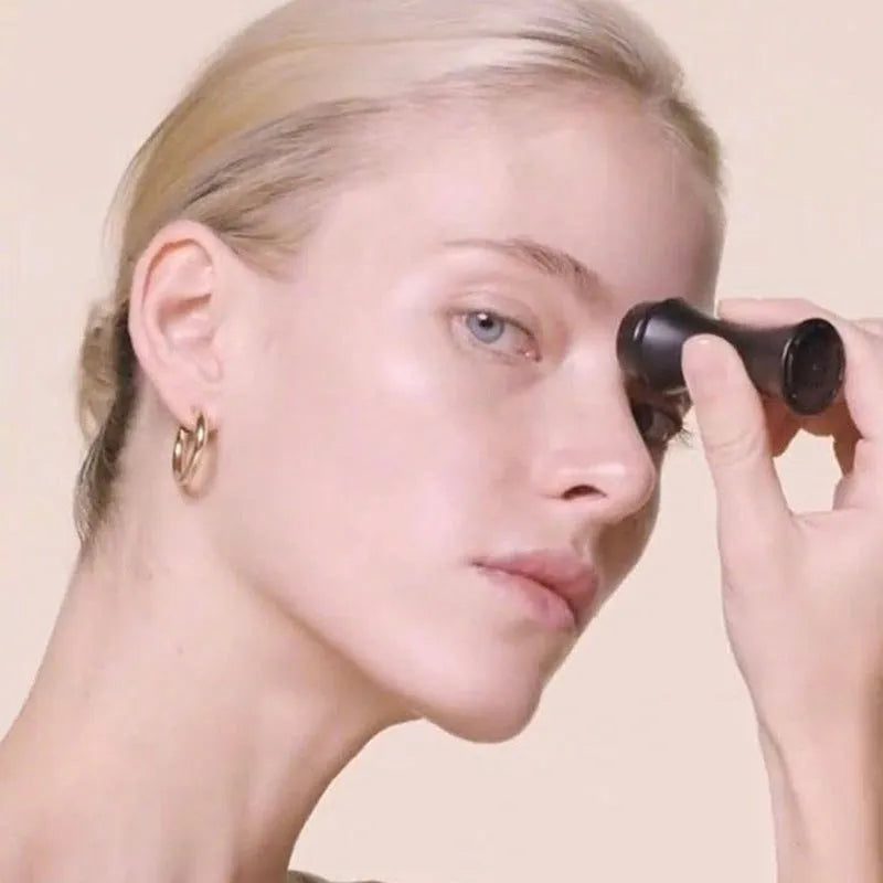 Portable black volcanic stone facial roller for oily skin control and makeup touch-ups.