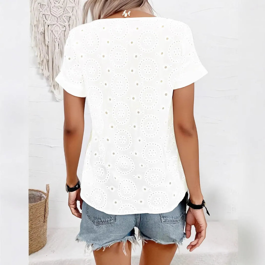 White women's V-neck t-shirt with hollow out detail and short sleeves on a hanger.