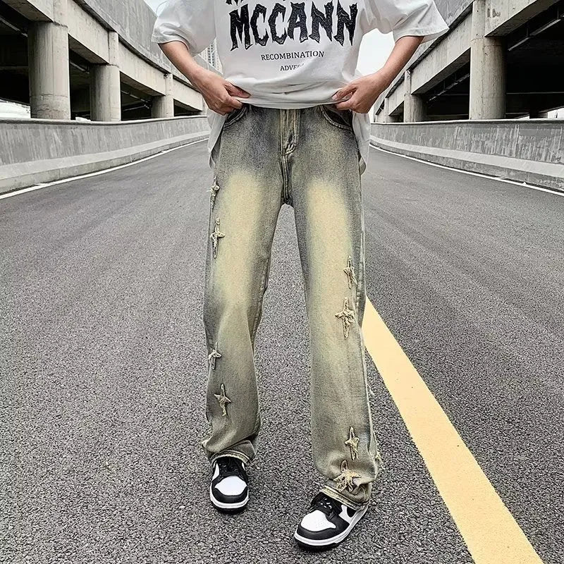 Men's loose denim trousers in black, straight-leg style with zipper fly, lying flat on a surface