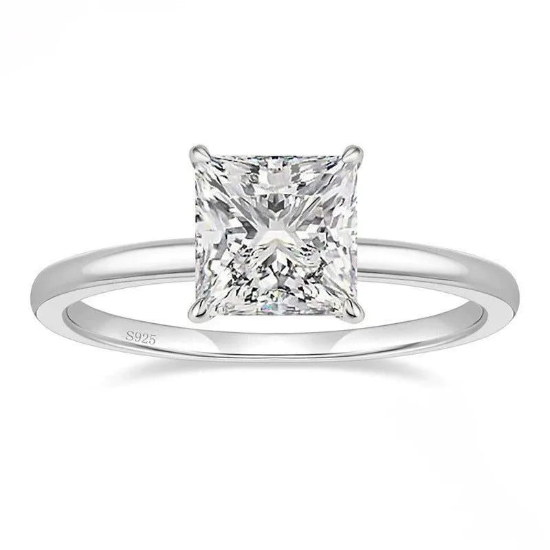 A polished geometric sterling silver ring for women on a grey background.