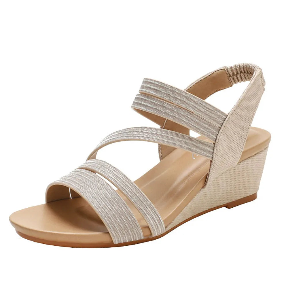 Gold women's platform sandals with a medium heel on a grey background.