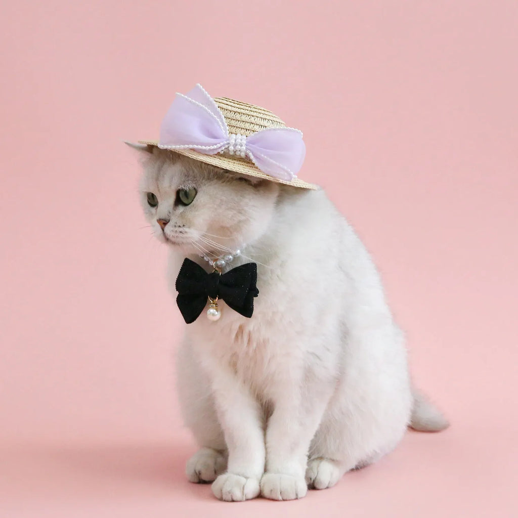 Pink pearl bow straw hat for a cat on a mannequin head, showing Lafite leaf weave and butterfly detail.