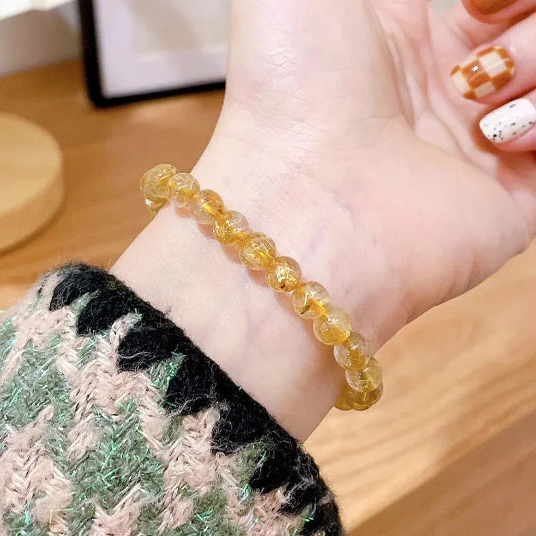 Gold rutilated quartz and sunstone bracelet with round diamond-cut beads for women