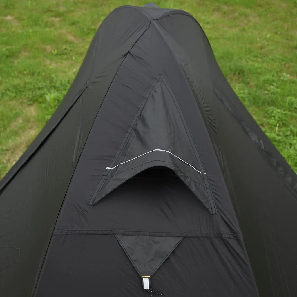 Lightweight red single person tent with aluminium poles pitched outdoors.