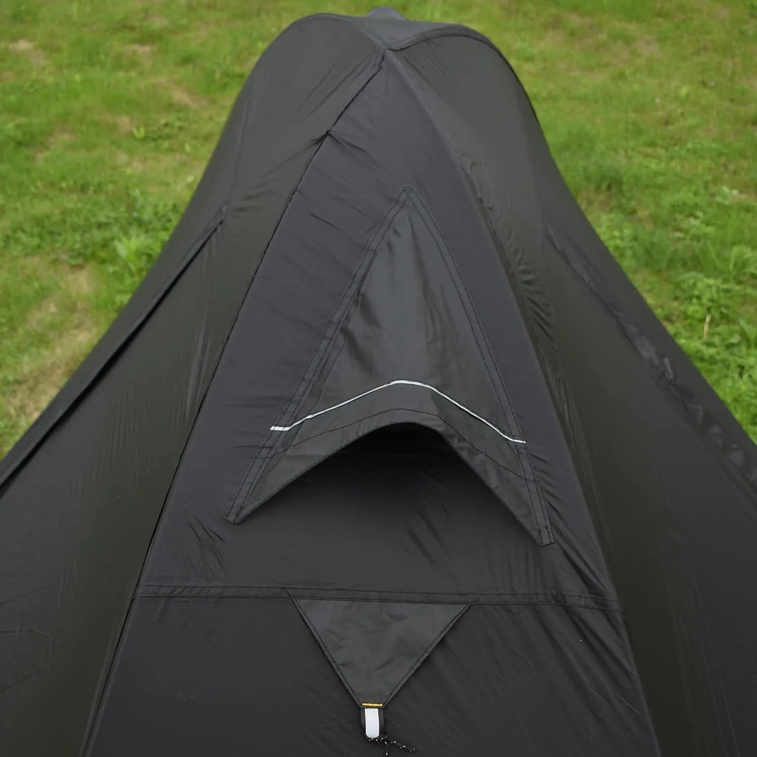 Lightweight red single person tent with aluminium poles pitched outdoors.