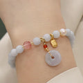 Gold plated women's bracelet with aquamarine chalcedony crystal pendant and floral design.
