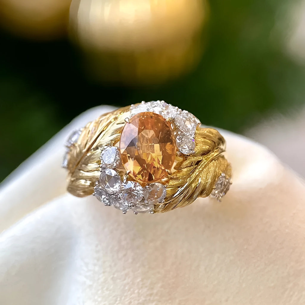 Gold women's ring with embossed feather design and yellow zircon stones on geometric shape