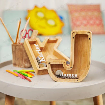 Unique wooden coin bank in the shape of a letter, featuring a clear glass display to watch savings grow