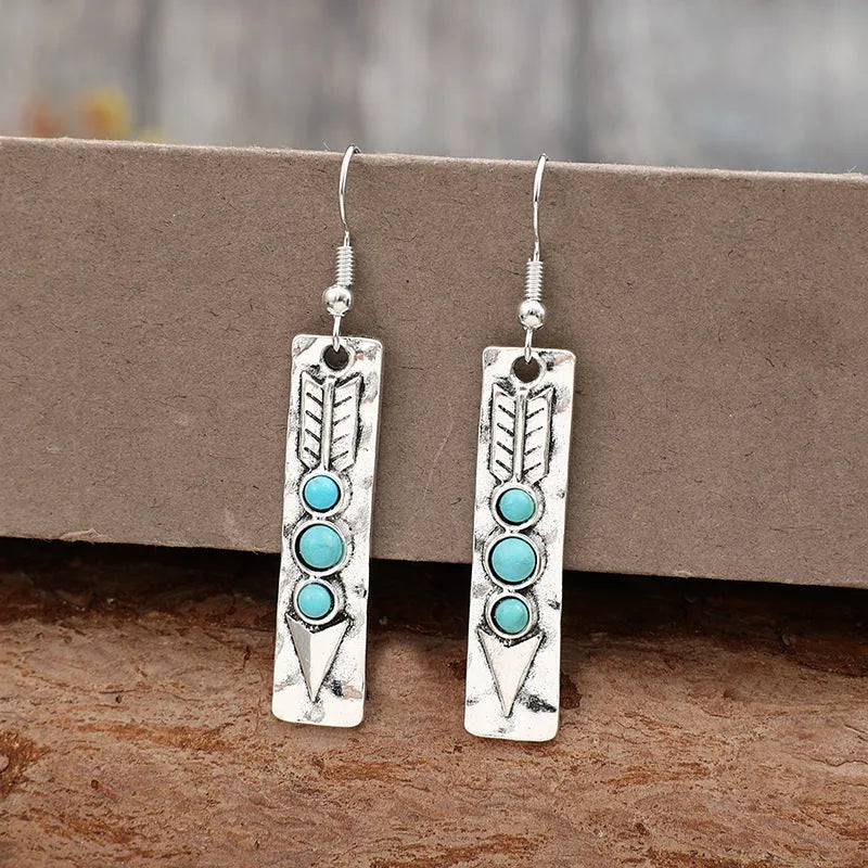 Long silver geometric drop earrings with inlaid turquoise details on a retro-style zinc alloy setting.