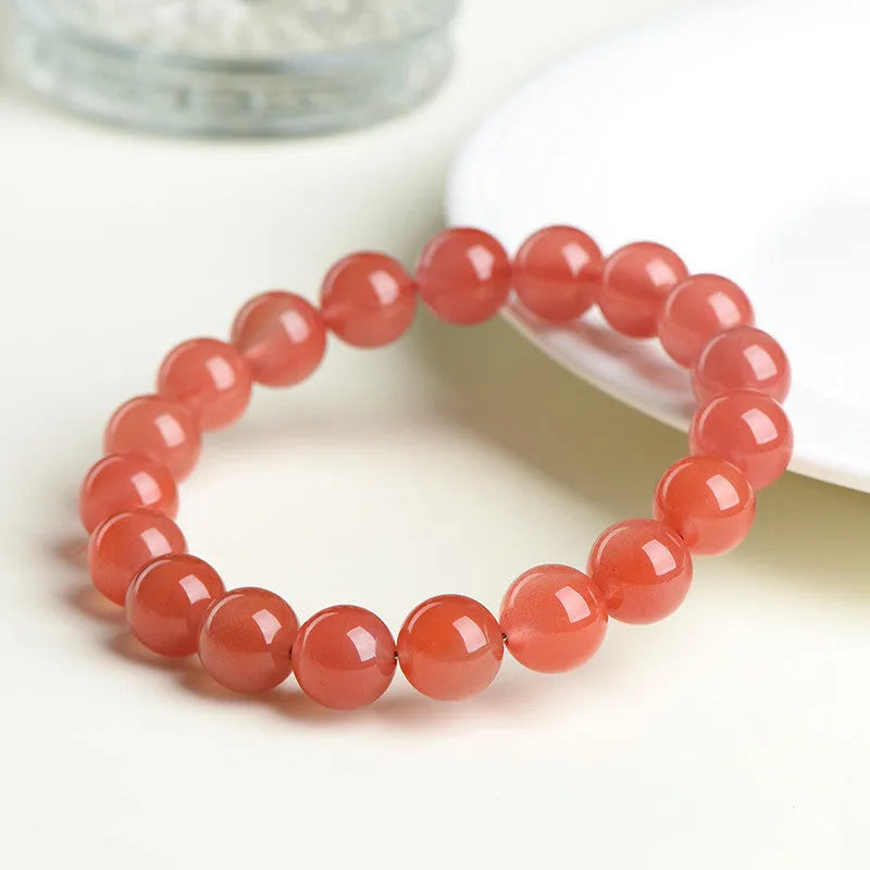 Natural South Red Cherry Agate bracelet on a wrist, showing polished beads in a single strand design.