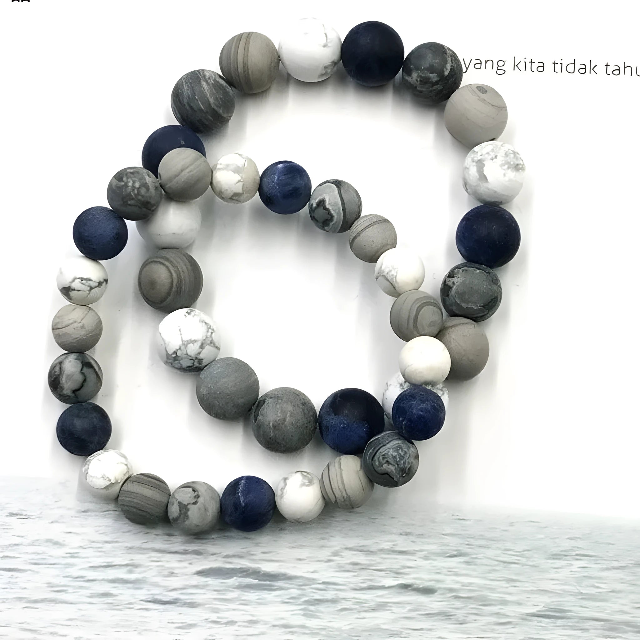 Handmade natural planet stone bracelet with starry design on a wrist, showing U-shaped profile.