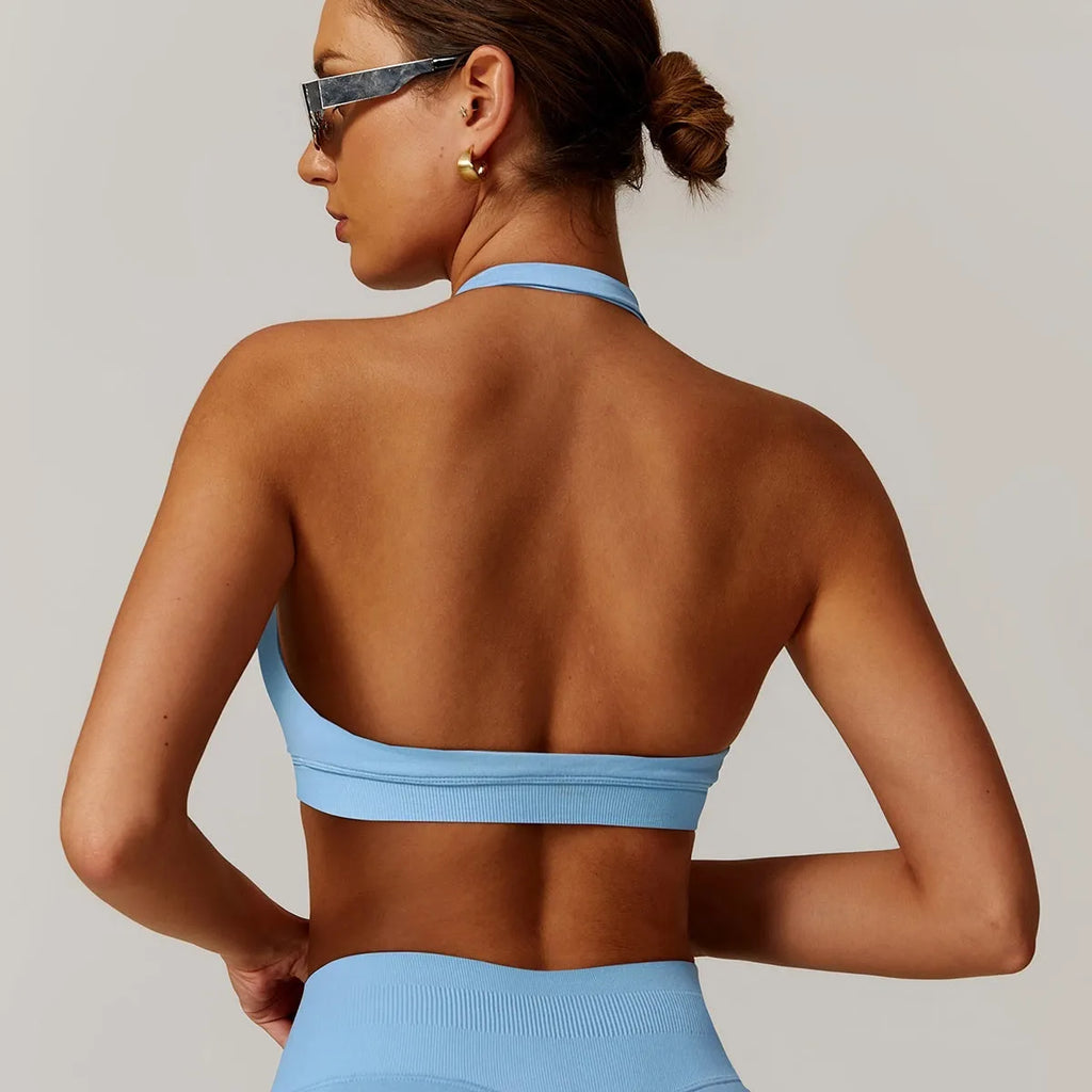 Women's black halter sports bra with hollow back and removable padding for yoga and workouts.