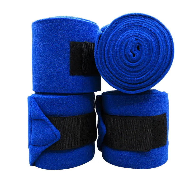 Set of four thick fleece double-sided plush horse leg guards in assorted colours on a stable floor