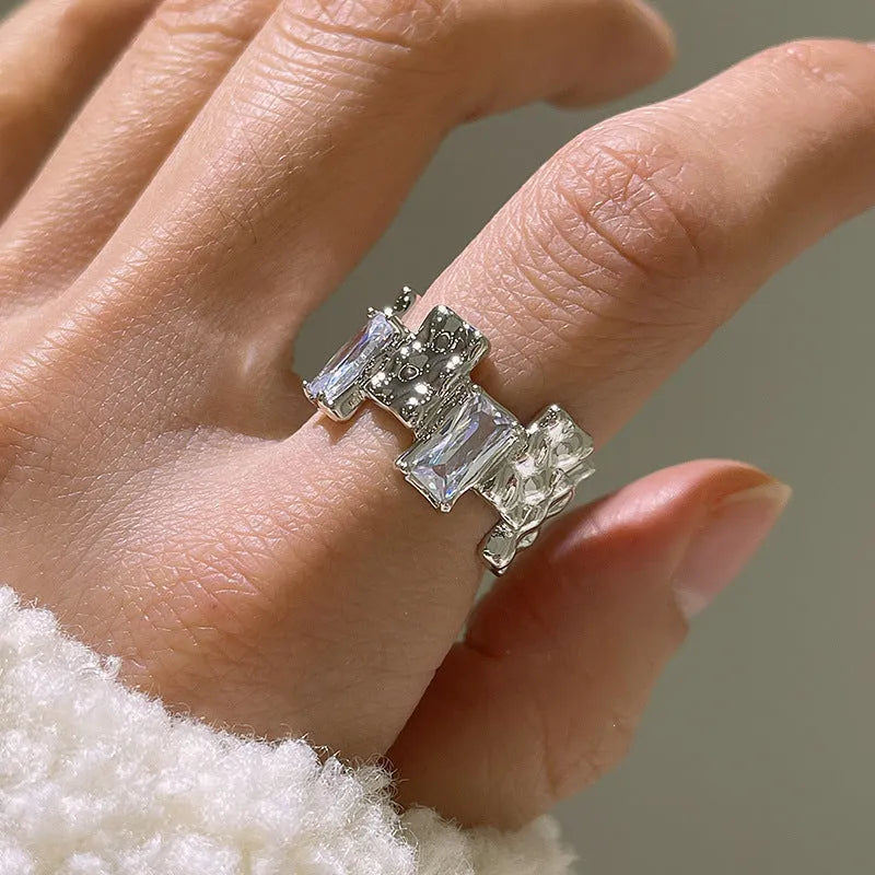Silver geometric cross ring with open gemstone setting and retro national fashion decorative elements.