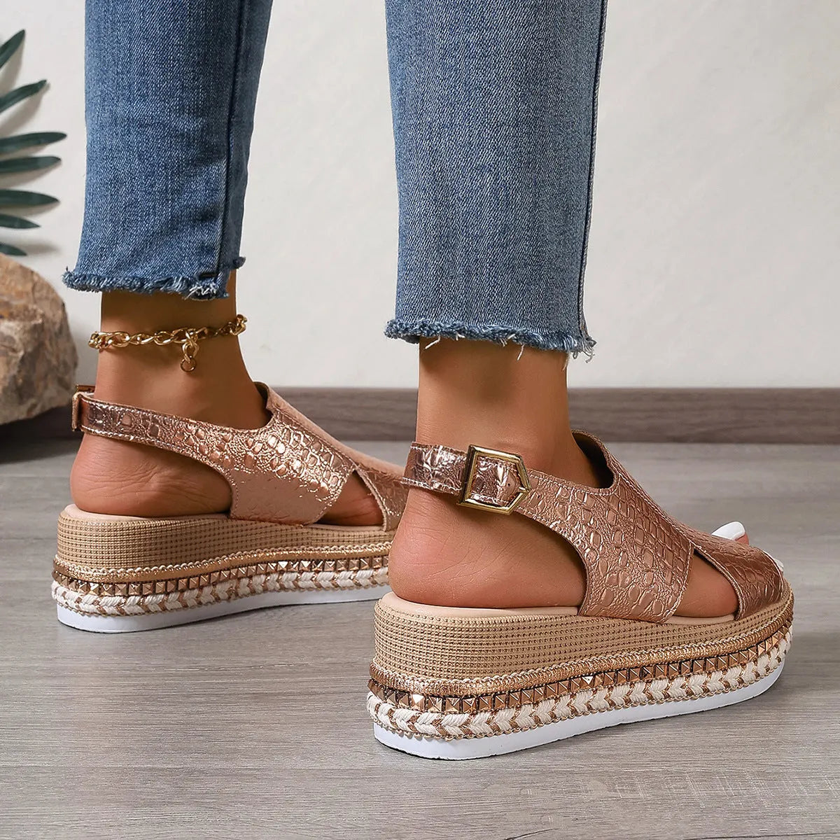 Gold Roman sandals with hollow-out pattern and ankle buckle on model foot